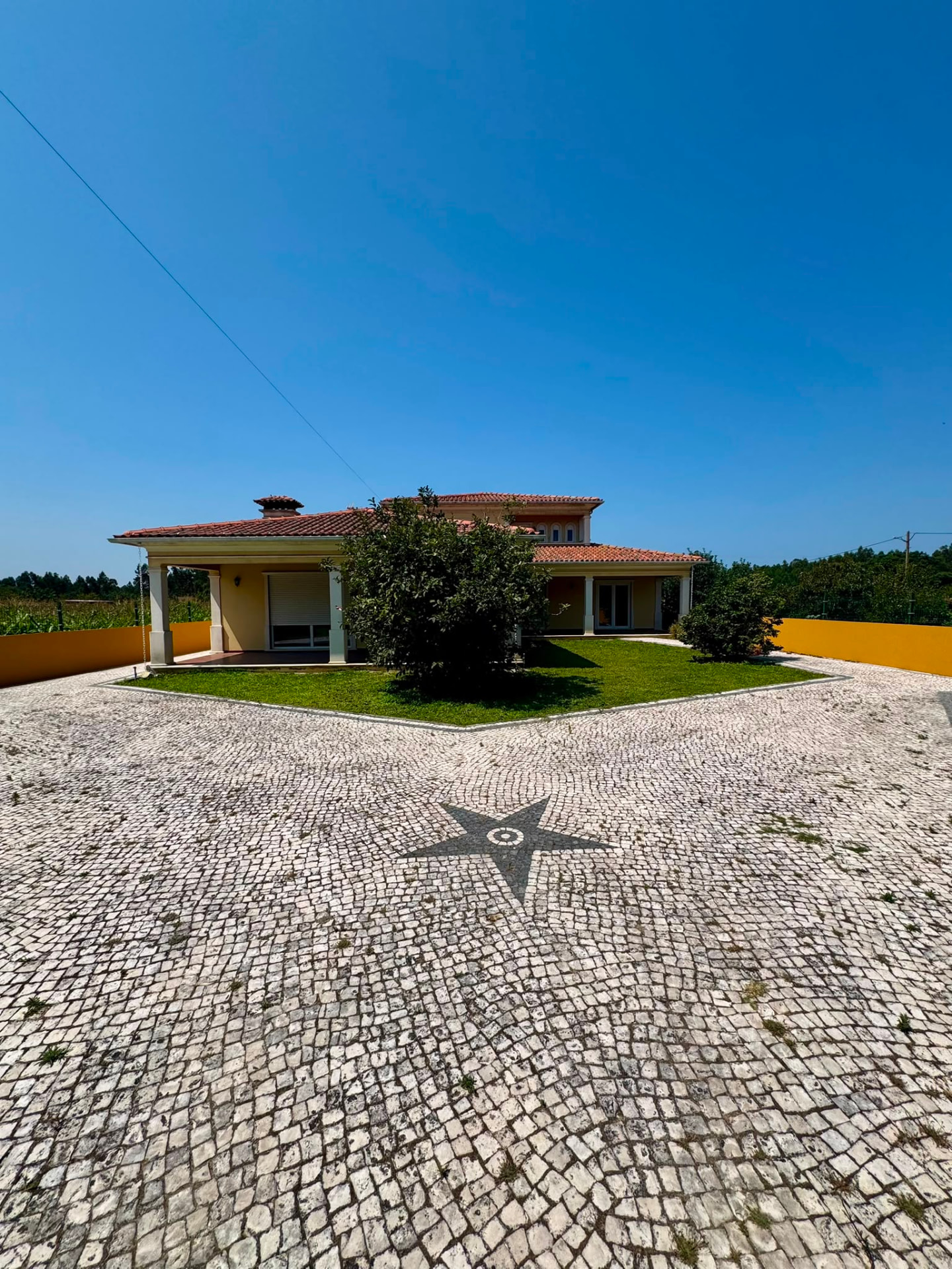 Front of West Gold in Corujeira, Mira — Portuguese pavement with compass rose and garden